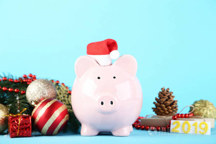 圣诞老人礼帽上的粉红色小钱包，蓝色背景上的圣诞装饰品