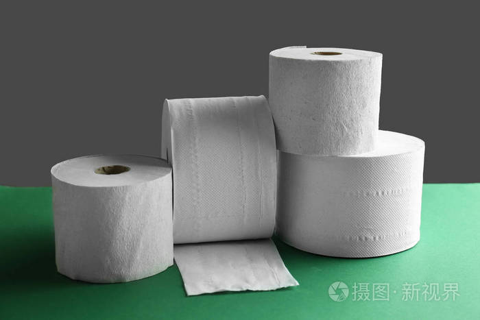 桌子上的一卷卫生纸在黑暗的背景下