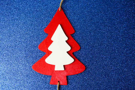 节日新年圣诞节快乐美丽的蓝色闪光的背景与一个小玩具木自制可爱的圣诞树。平躺着。顶部视图。节日装饰品