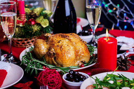 圣诞餐桌上摆着一只火鸡，上面装饰着明亮的金箔和蜡烛