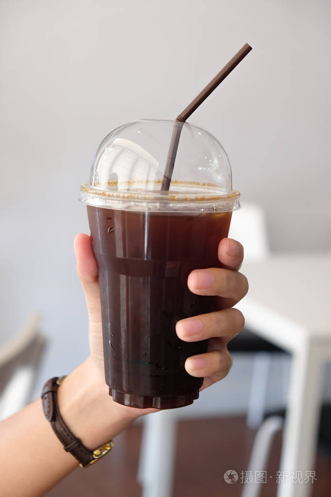 冰美式黑咖啡在女孩手中. 带走饮料概念