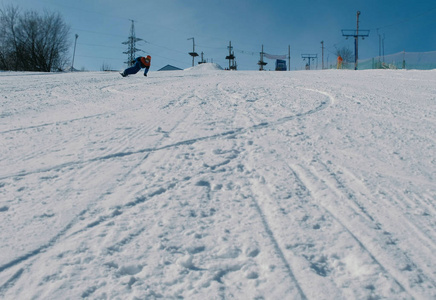 12岁的十几岁的男孩从雪下降下一个天空电梯在滑雪板上滑行
