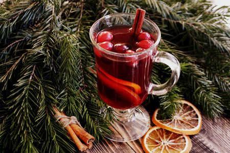 圣诞覆盖葡萄酒与蔓越莓在玻璃。 冬暖酒，香料，冷杉，肉桂，干橙