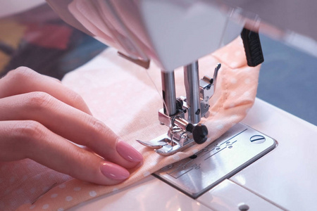 缝纫机上的女人缝制细节。特写手