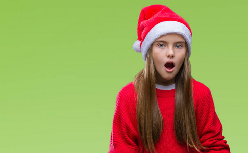 年轻漂亮的女孩戴着圣诞帽，在孤立的背景下害怕和震惊，惊讶的表情，恐惧和兴奋的脸。