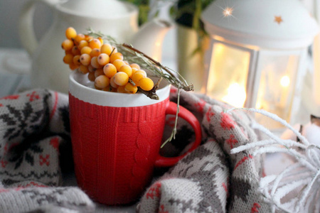 冬天，舒适的背景红茶，带装饰羊毛围巾，手电筒，水壶，黄色浆果的枝条