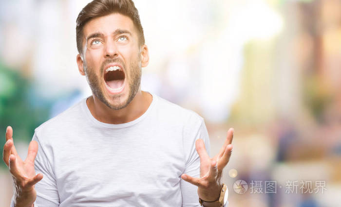 年轻的帅哥在孤立的背景下疯狂疯狂地大喊大叫,表情咄咄逼人,手臂抬起