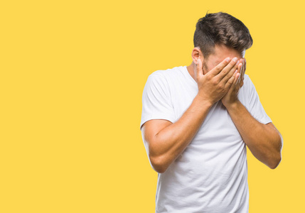 年轻的英俊男子,长发戴着眼镜,在孤立的背景下沮丧,担心痛苦,哭泣