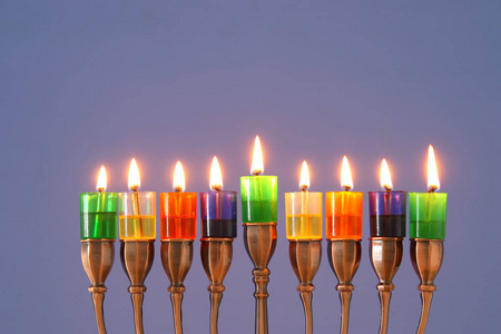 犹太节日光明节背景与米诺拉传统烛台和彩色油烛的形象
