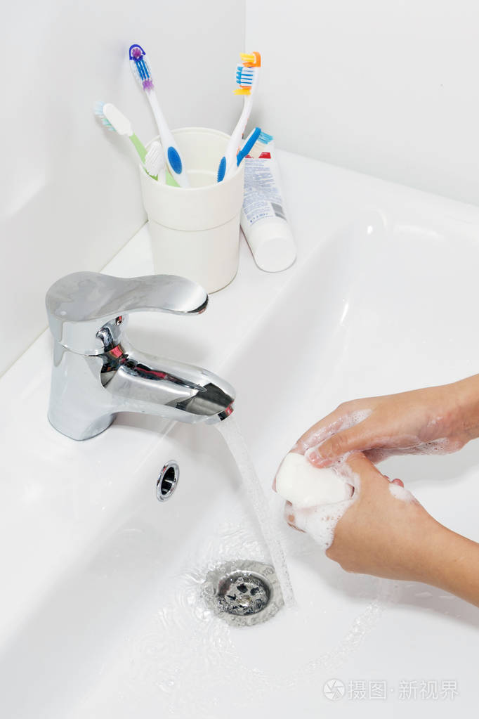 卫生概念用肥皂在水龙头下用水洗手