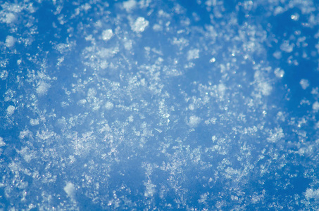 晴天下雪。 抽象的闪亮的雪背景。 蓝色雪质地背景