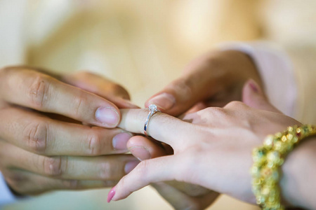 结婚戒指。 他把结婚戒指戴在她身上。 把戒指戴在新娘身上。 泰国婚礼和泰国婚礼装饰。