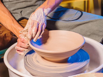 创造陶器和传统陶器的概念。经验丰富的男性波特手创造美丽的粘土产品碗使用的专业工具。色调影院, 工艺工厂正宗