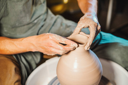 未知的工匠创造水罐。只专注于双。小企业人才灵感理念。视图。艺术工作室陶工轮人工作的过程