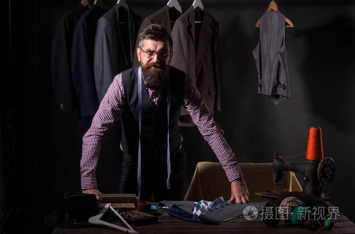 有胡子的人裁缝缝制夹克.复古和现代裁剪车间.服装店和时尚展厅.