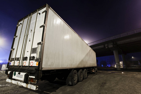 晚上在停车场有拖车的卡车照片