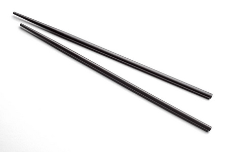白色背景下的黑色米饭筷子