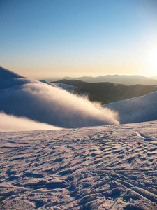 白雪覆盖了高高的山峰。 雾流过山。 荒凉的蓝色极端的冬季景观