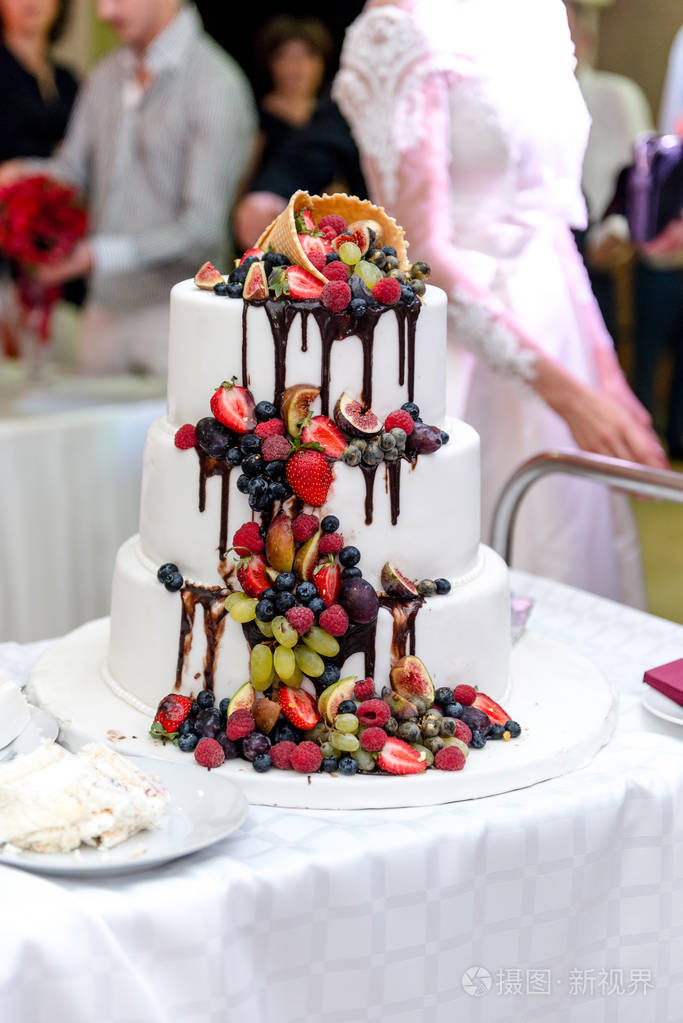 婚礼桌上放着水果的白色婚礼大蛋糕.