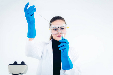 年轻女科研人员的画像是通过显微镜在实验室中混合化学和分析结果.