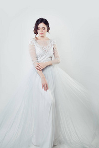 迷人的新娘肖像。 穿着白色时髦连衣裙的完美女人