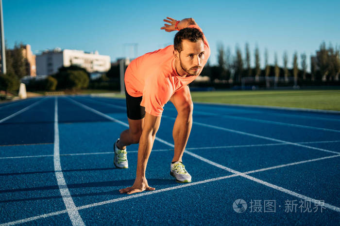 短跑运动员准备在赛道上比赛.