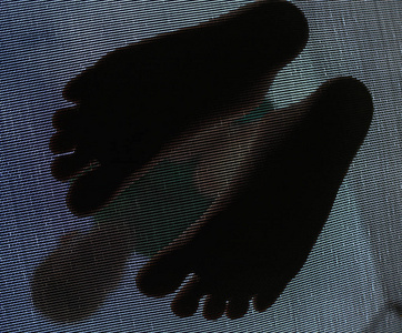 一个孩子光着脚在蹦床上蹦蹦跳跳照片