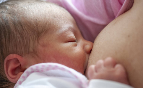 s milk. Mother breastfeeding baby in the first day of life, birt