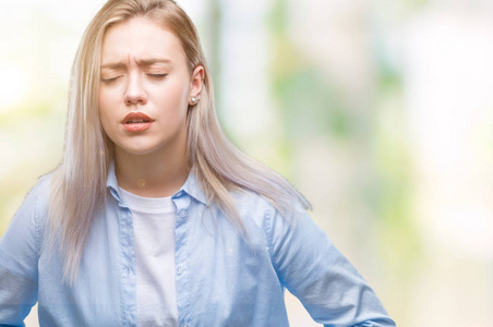 年轻的金发女人过孤立的背景，手在肚子上，因为消化不良，痛苦的疾病，感觉不舒服。 疼痛的概念。