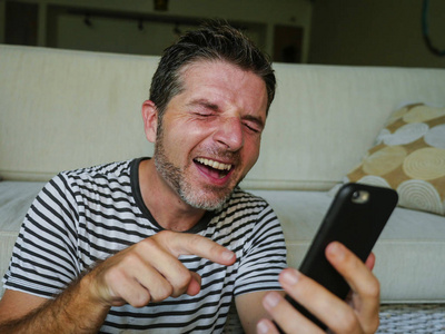 人笑得像疯了一样用手机看一些有趣的东西在互联网社交媒体上享受快乐