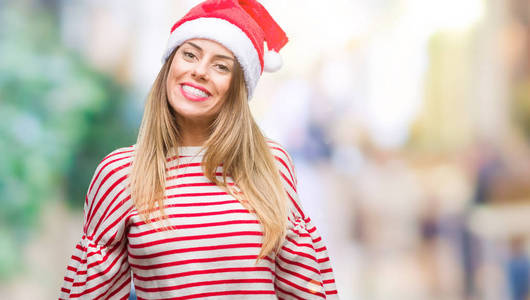 年轻漂亮的女人戴着圣诞帽，在孤立的背景上，脸上带着快乐和凉爽的微笑。 幸运的人。