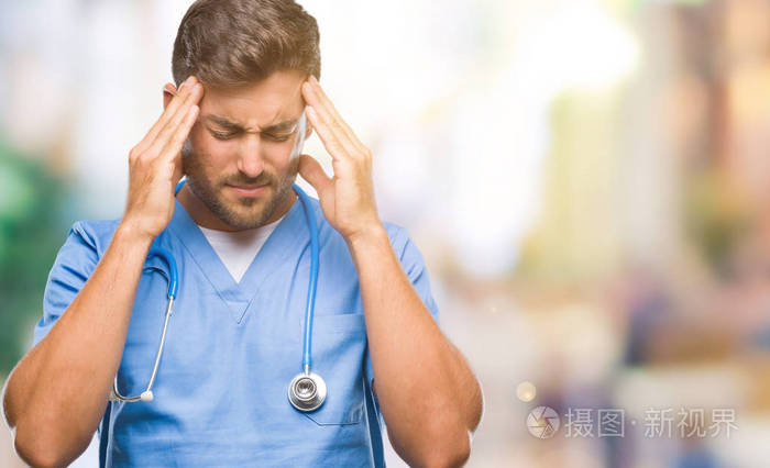 年轻英俊的医生外科医生，男人在孤立的背景上，手在头上疼痛，因为压力。 偏头痛。