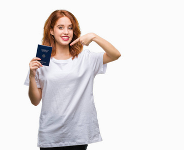 年轻美丽的女子，手拿着德国护照，背景偏僻，很高兴用手和手指指指点点。