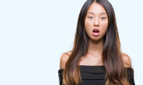 年轻的亚洲女人在孤立的背景下害怕和震惊,惊讶的表情,恐惧和兴奋的脸