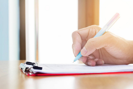 用钢笔在纸上写字的手照片