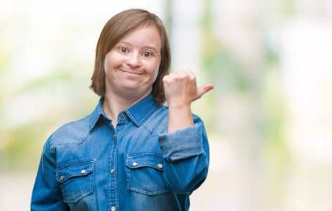 年轻的成年妇女患有唐氏综合症，在孤立的背景上微笑，快乐的脸看着，用拇指向上指向侧面。