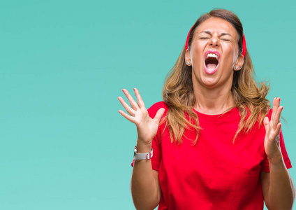 中年老年西班牙裔妇女在孤立的背景下疯狂和疯狂地大喊大叫,带着咄咄