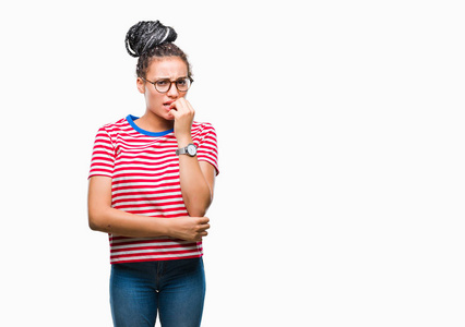 年轻的辫子非裔美国女孩戴着眼镜，在孤立的背景上看起来压力和紧张，双手咬着嘴的指甲。 焦虑问题。