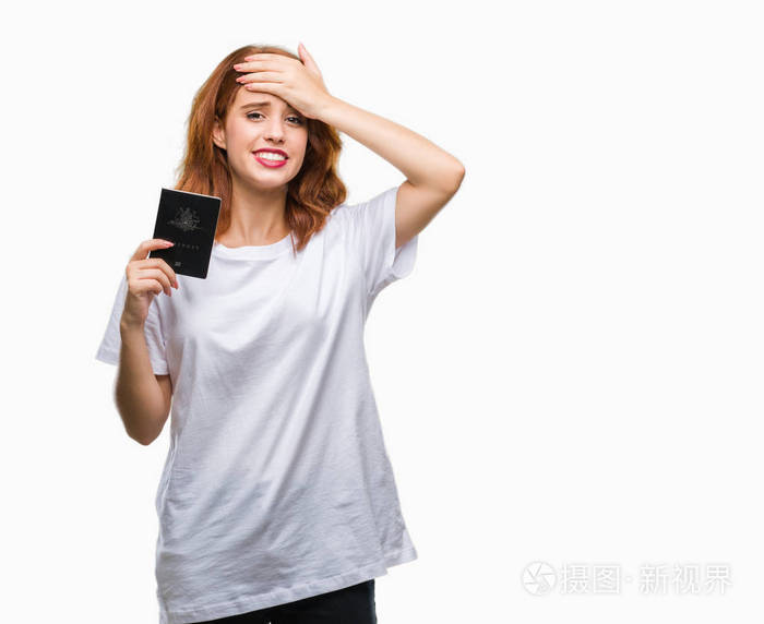 年轻漂亮的女人拿着澳大利亚护照,在孤立的背景下,用手压着头,羞愧和