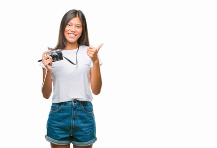 年轻的亚洲女人在孤立的背景上指着相机，带着快乐和有趣的脸。 良好的能量和氛围。