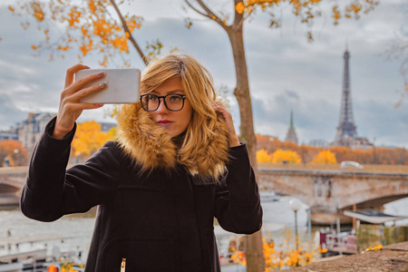 女孩使用手机与巴黎城市背景和埃菲尔铁塔。