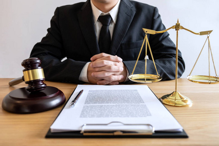 法律咨询和司法概念男性律师或公证人工作的文件和报告的重要案件和木槌平衡在法庭上。