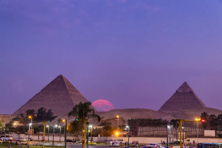 从吉萨城日落时看到吉萨大金字塔，满月升起