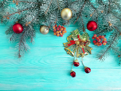 圣诞树树枝上的蓝色木制背景雪架松果