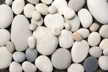 大鹅卵石一组轻的,小的和大的鹅卵石,分为两层,简单的石头背景照片