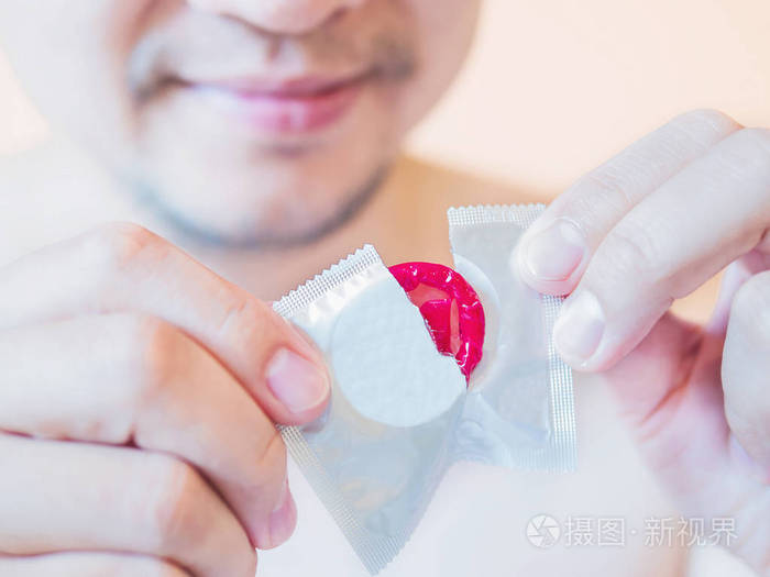 男人撕红避孕套包安全的性概念