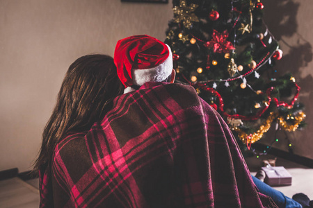 s hat and hugging. Young people celebrating New year at home at 