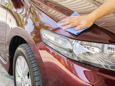 s hand is cleaning and waxing the car