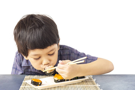 亚洲可爱的男孩在白色背景下吃寿司