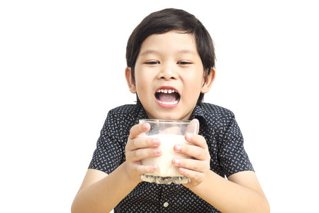 亚洲男孩正在喝一杯牛奶，牛奶被隔离在白色背景上